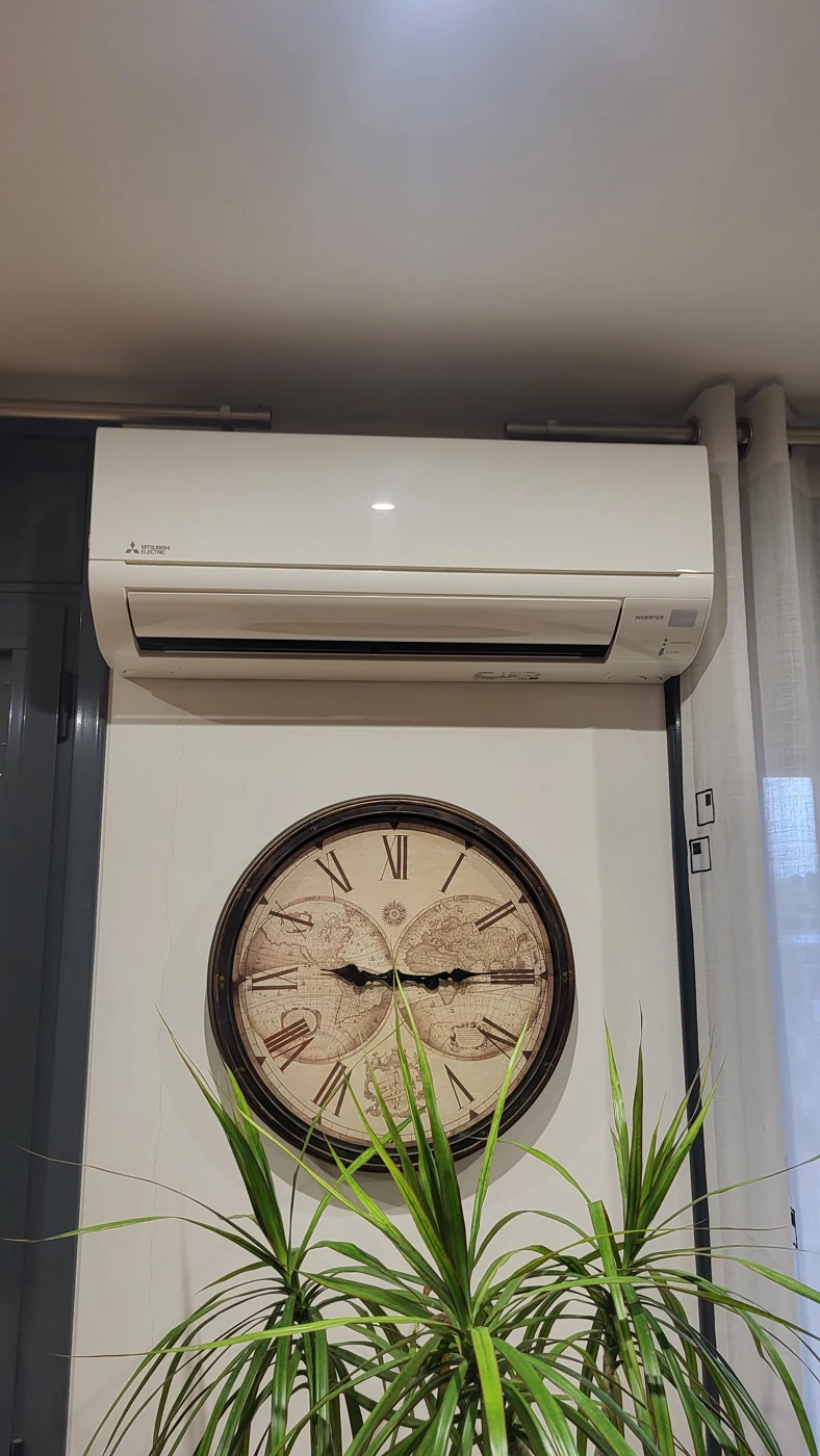 Aire acondicionado Mitsubishi Electric instalado sobre un reloj de pared grande