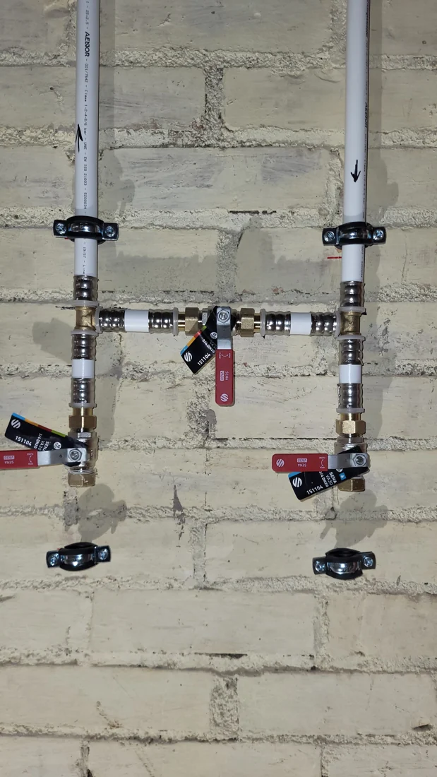 Tuberías multicapa y válvulas fijadas a la pared durante una instalación de agua